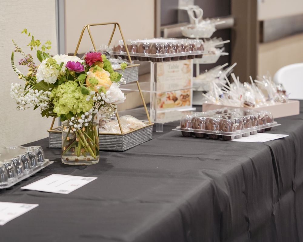 Dessert table with fresh flowers, chocolate cupcakes and cake pops at the CASA Fashion Show