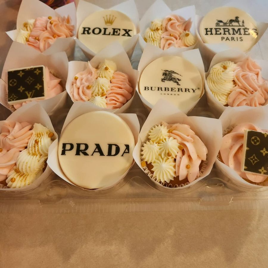 Pink and cream cupcakes with designer logo toppers
