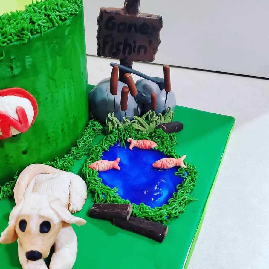 Cake with a Gone Fishin sign, pond with fish and a sculpted dog