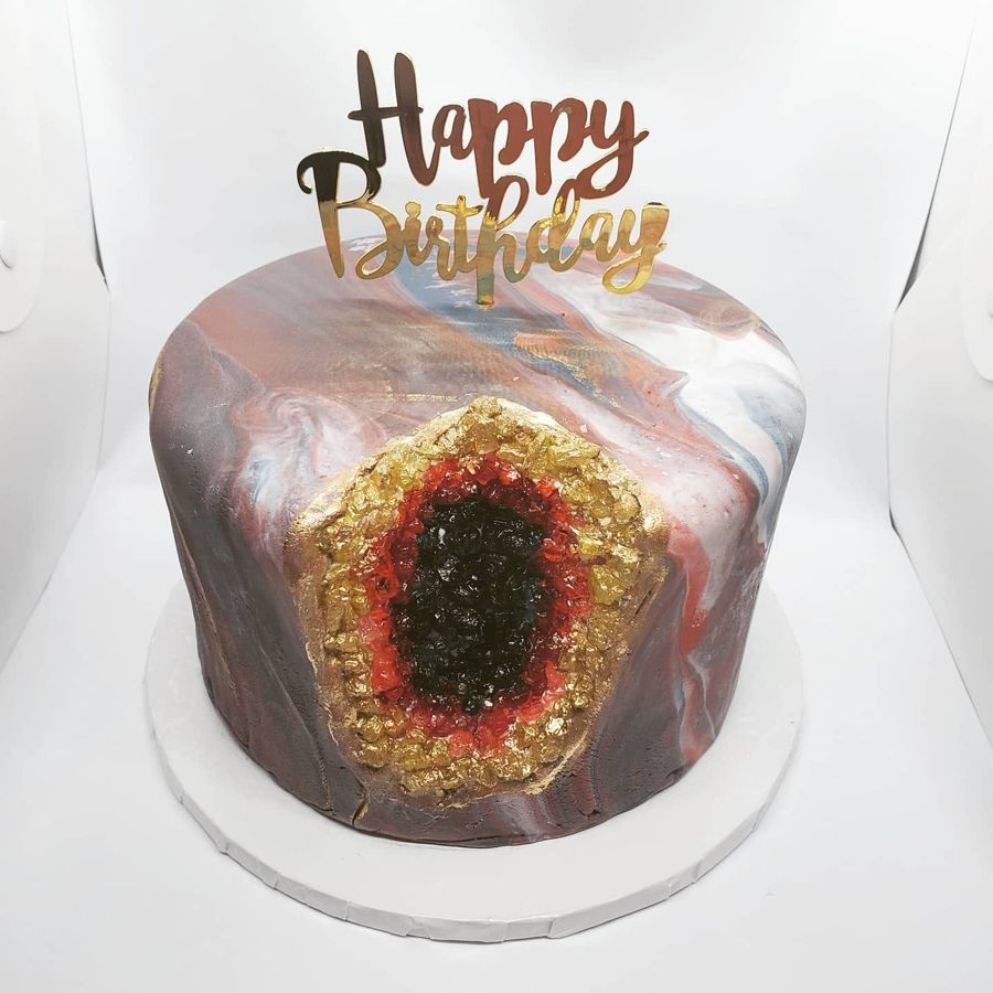 Marbled birthday cake with a red and gold candy geode